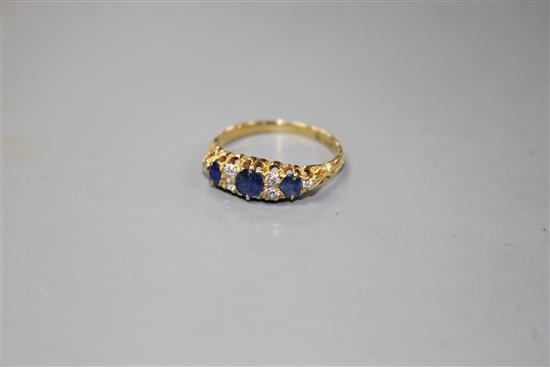 A George V 18ct gold, three stone sapphire and six stone diamond set half hoop ring,